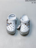 Pair of white platform clogs with decorative charms and adjustable heel straps.