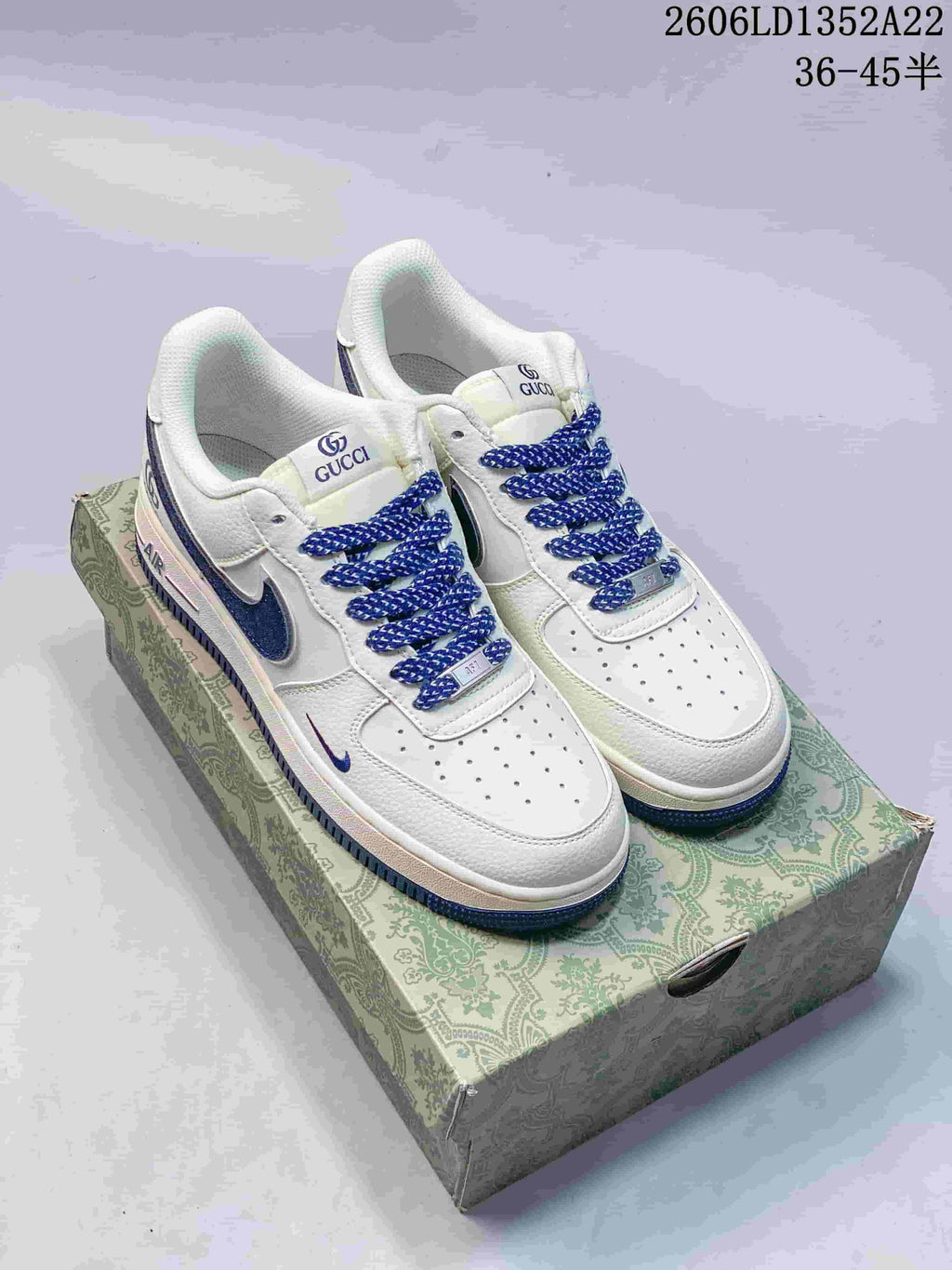 Pair of white and blue Nike Air Force 1-style sneakers on a patterned box; image text shows style code 2606LD1352A22 and size range 36–45.5.