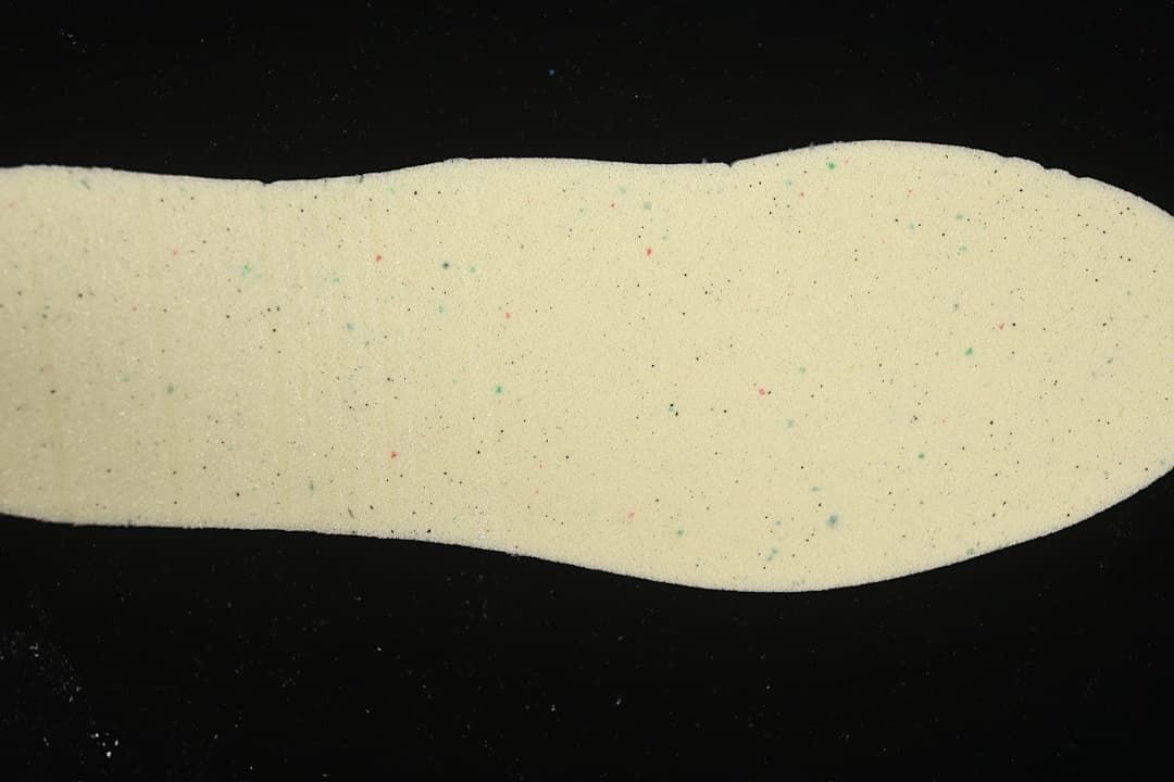 Close-up of a cream-colored shoe insole with small colored speckles.