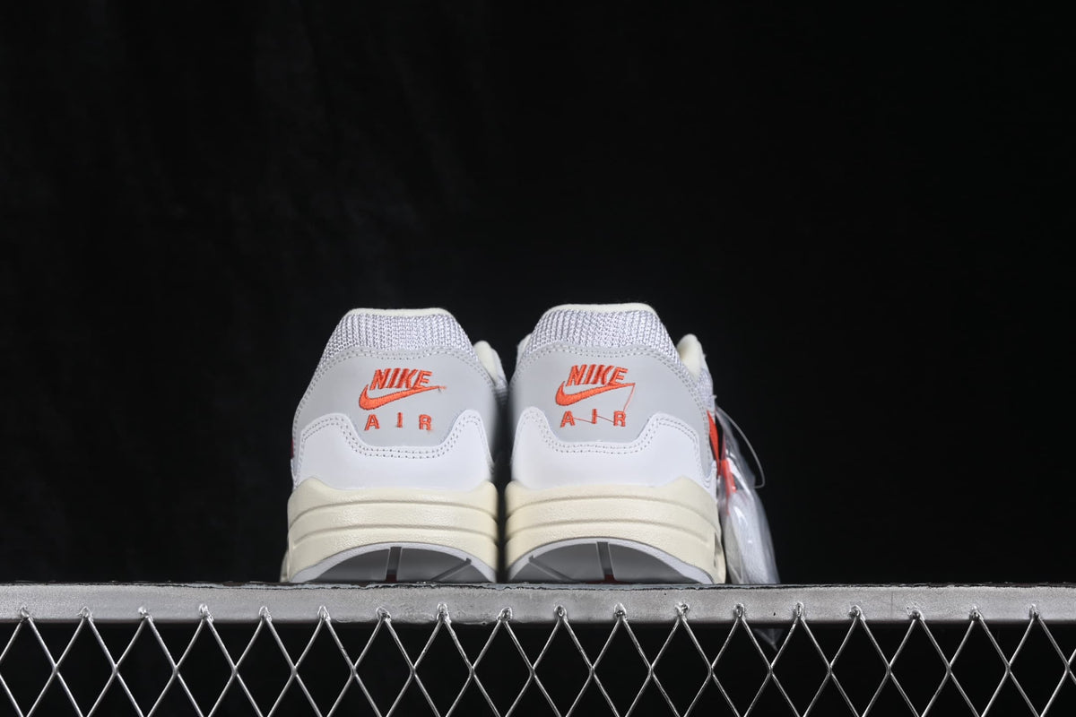 Rear view of the pair showing orange Nike Air heel branding, grey collars, and cream midsoles.