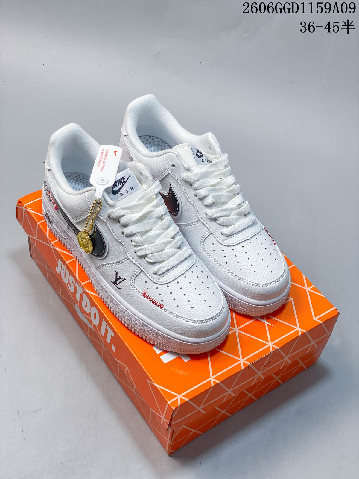 Pair of white low-top sneakers with dark side Swooshes, red accents, and an orange shoe box