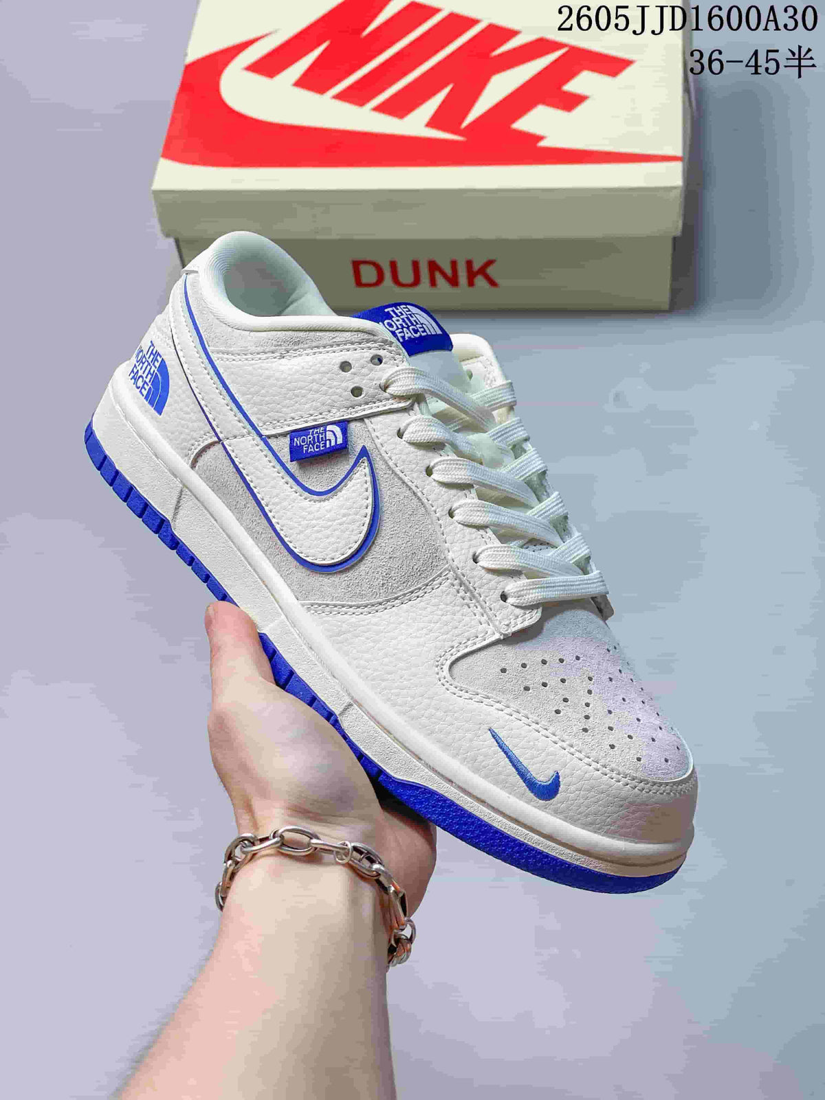 Angled side view of a white Nike SB Dunk Low sneaker with blue details and visible branding