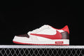 Side view of a red, white, and dark patterned low-top Air Jordan sneaker.
