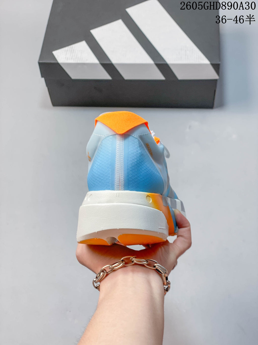 Rear view of the pale blue shoe with orange heel accents