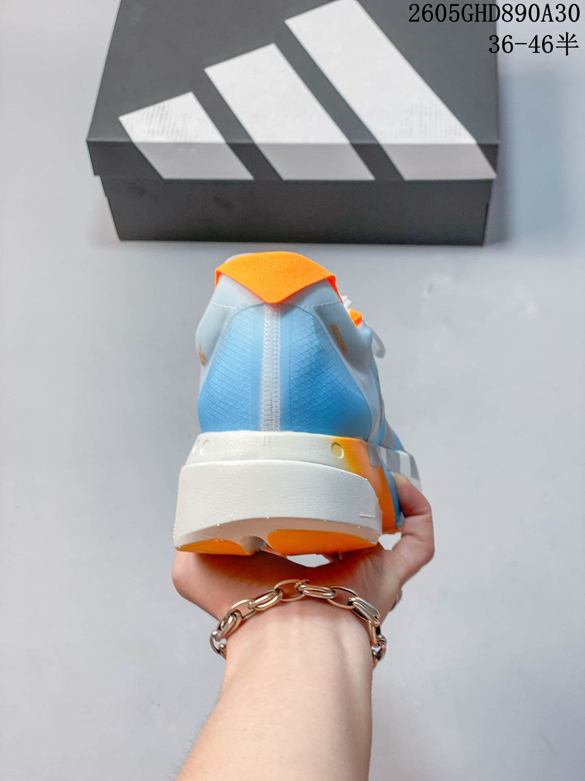 Rear view of the pale blue shoe with orange heel accents