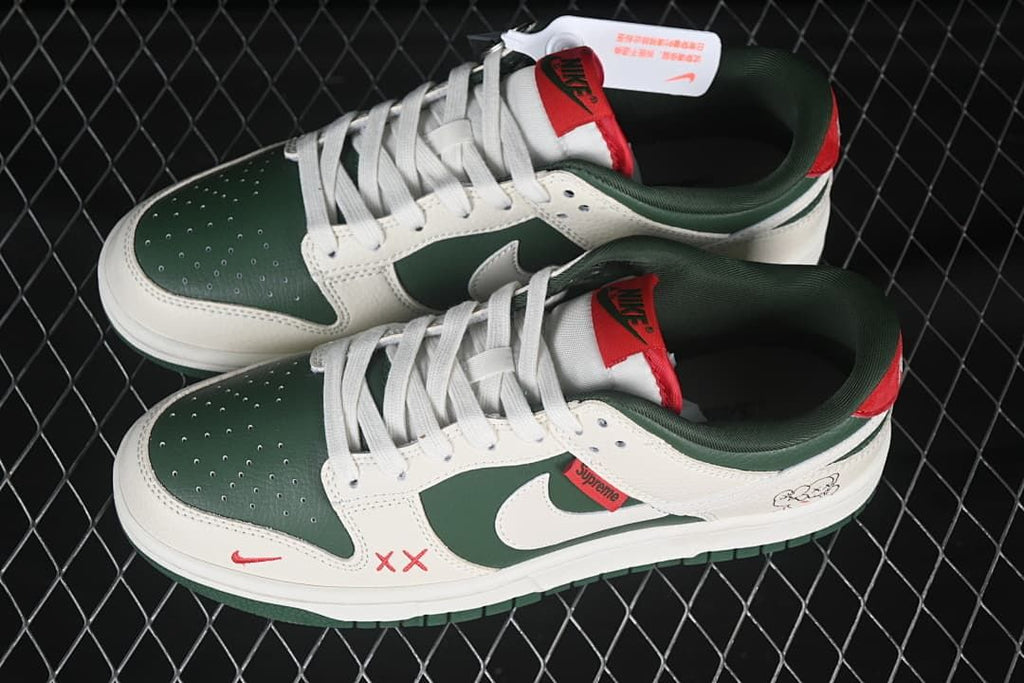 Top view of a pair of green and sail low-top sneakers with white laces and red accents