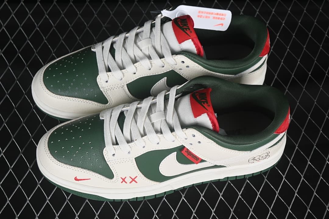 Top view of a pair of green and sail low-top sneakers with white laces and red accents