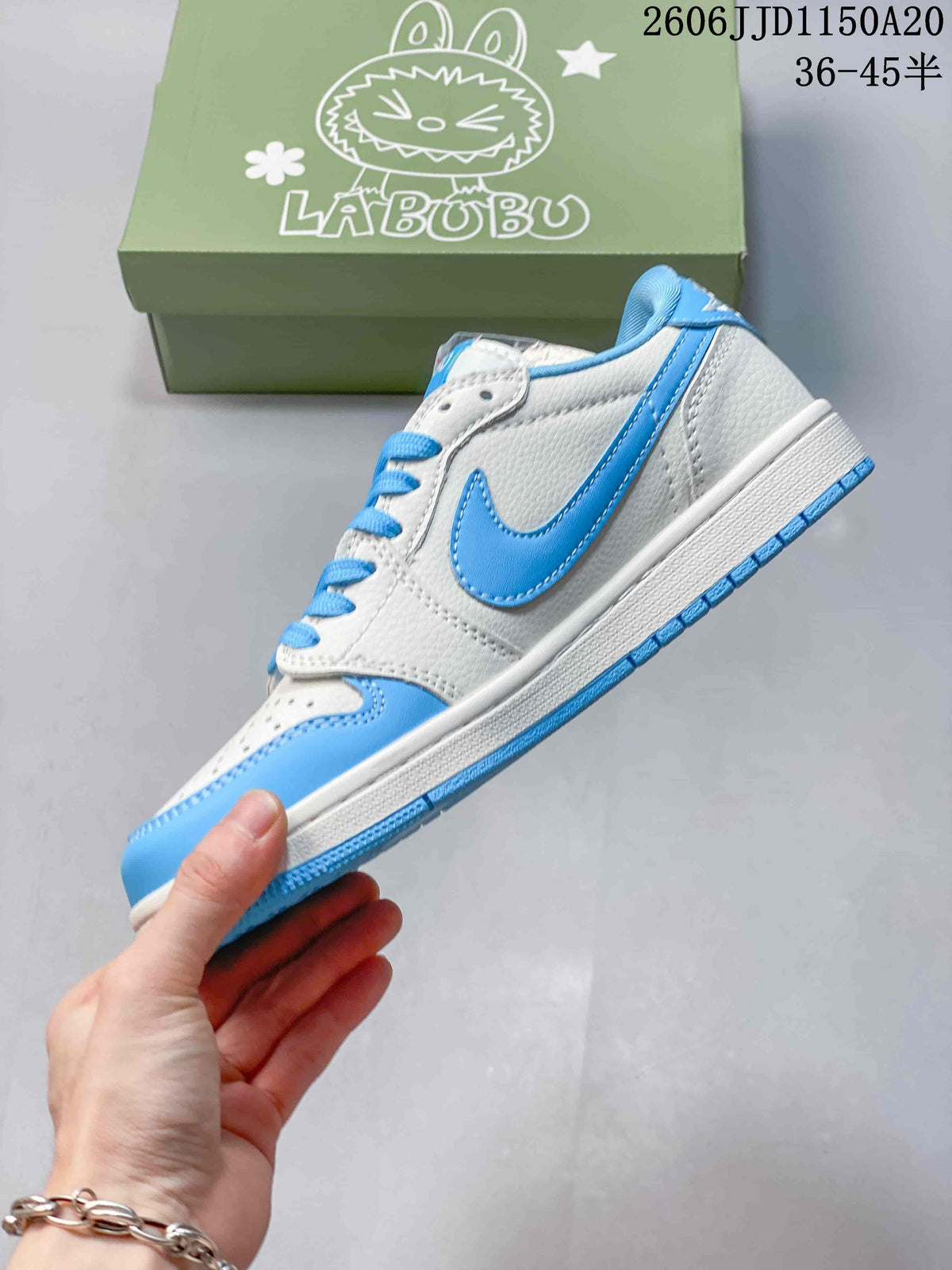 Side view of a white and blue low-top sneaker with a blue swoosh-shaped panel and character-printed box behind it.