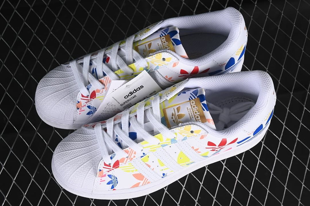 Pair of white multicolor adidas Superstar sneakers viewed from above