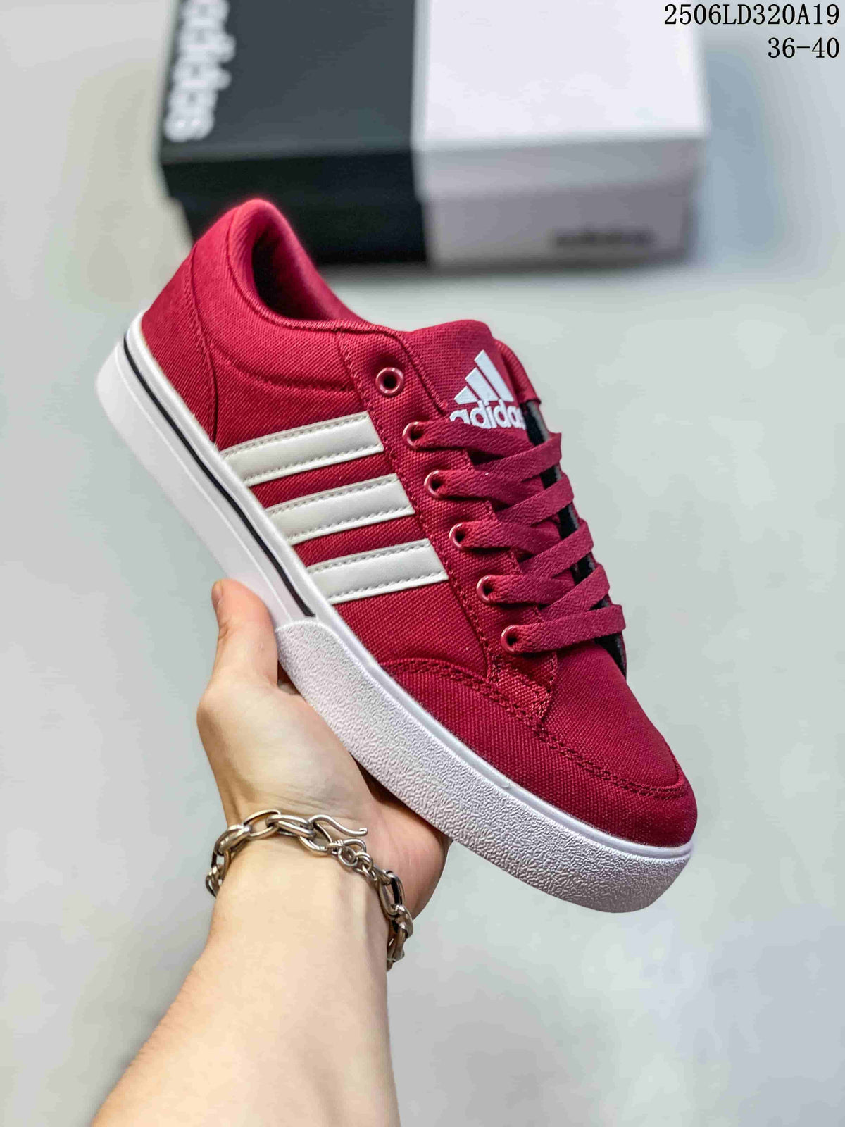 Angled side view of the burgundy sneaker with white stripes and a lace-up closure.