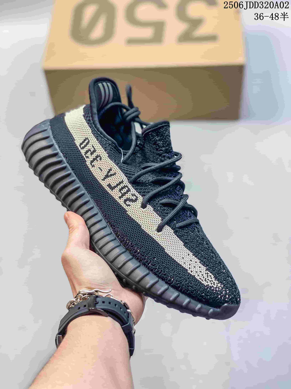 Black knit low-top sneaker with a cream side stripe and dark ribbed sole