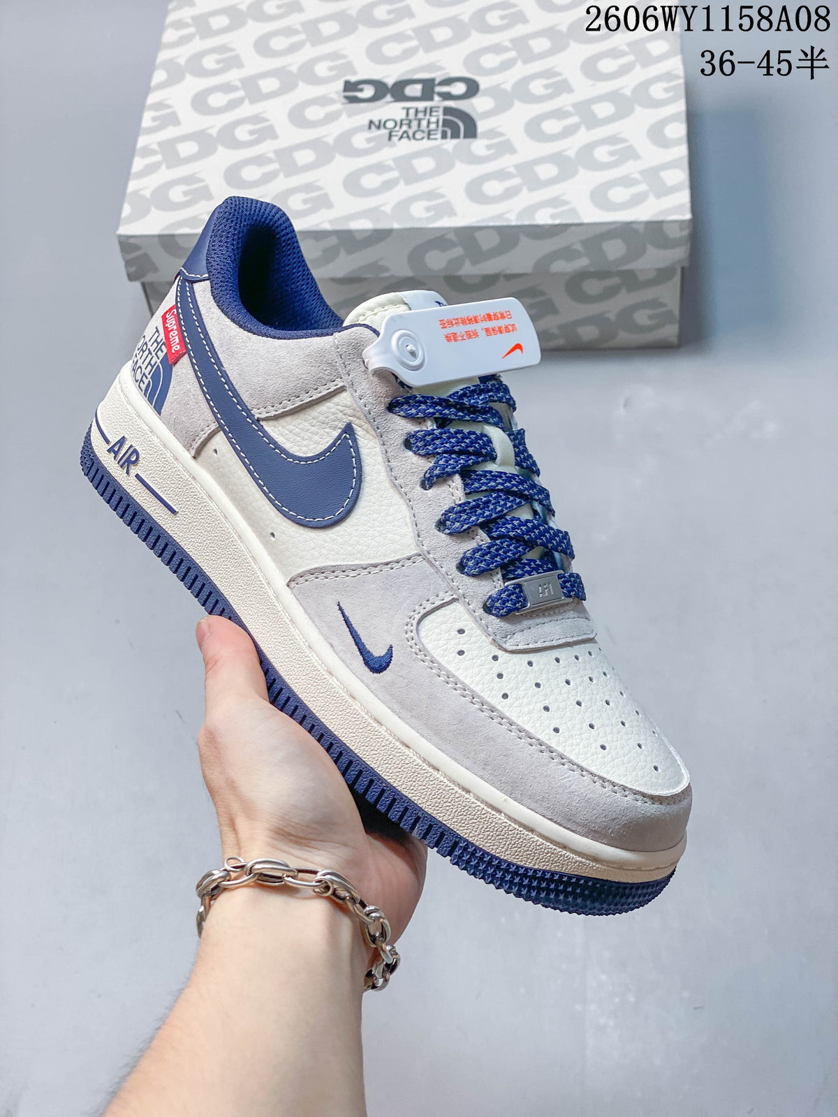 Close view of a light grey and off-white low-top sneaker with blue Swoosh and blue laces.