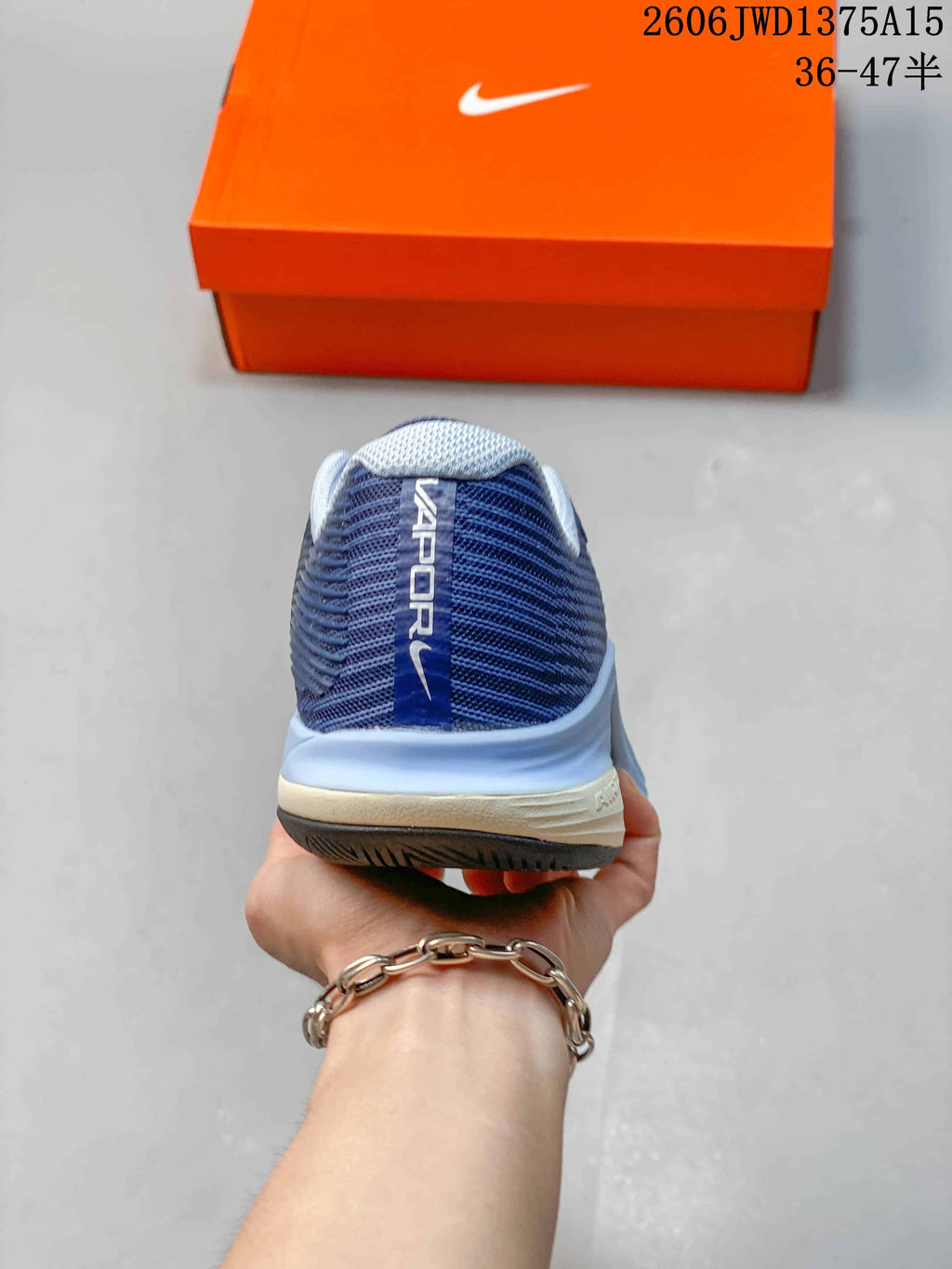 Rear view of a blue Nike Vapor 12 shoe with a padded-looking collar