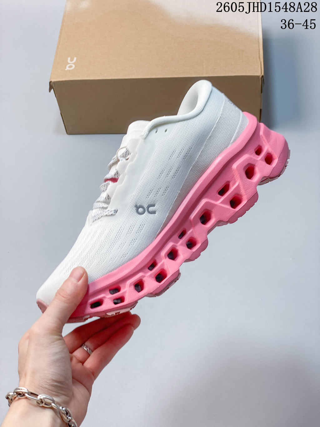 Side view showing the white upper and pink segmented sole