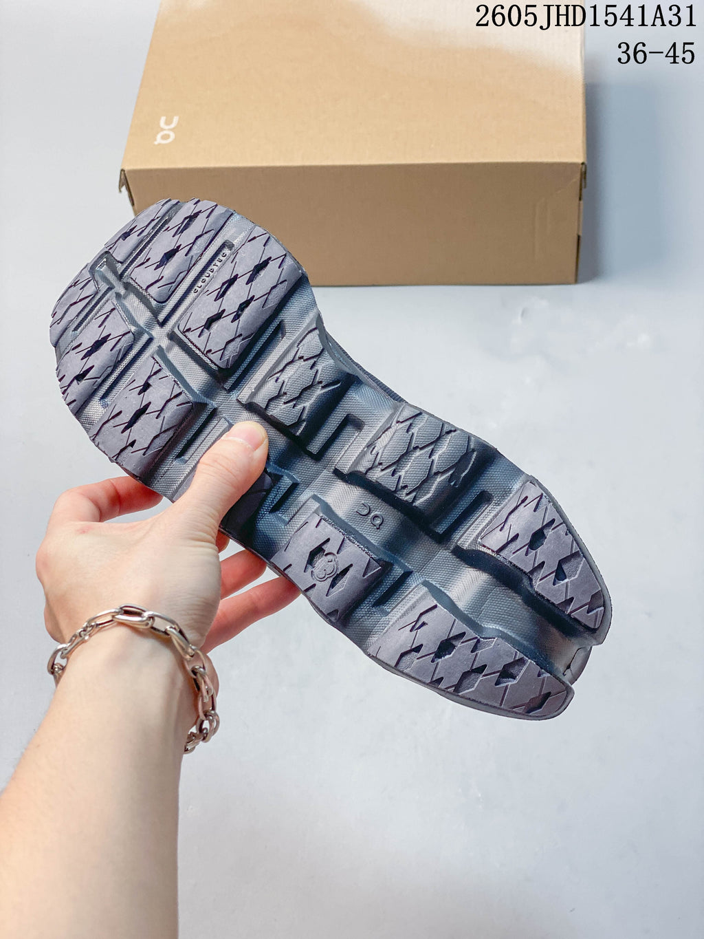 Close-up of the segmented patterned outsole on a charcoal running shoe.