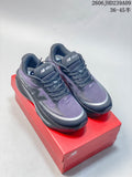 Pair of purple, gray, and dark navy New Balance Ellipse shoes on a red box