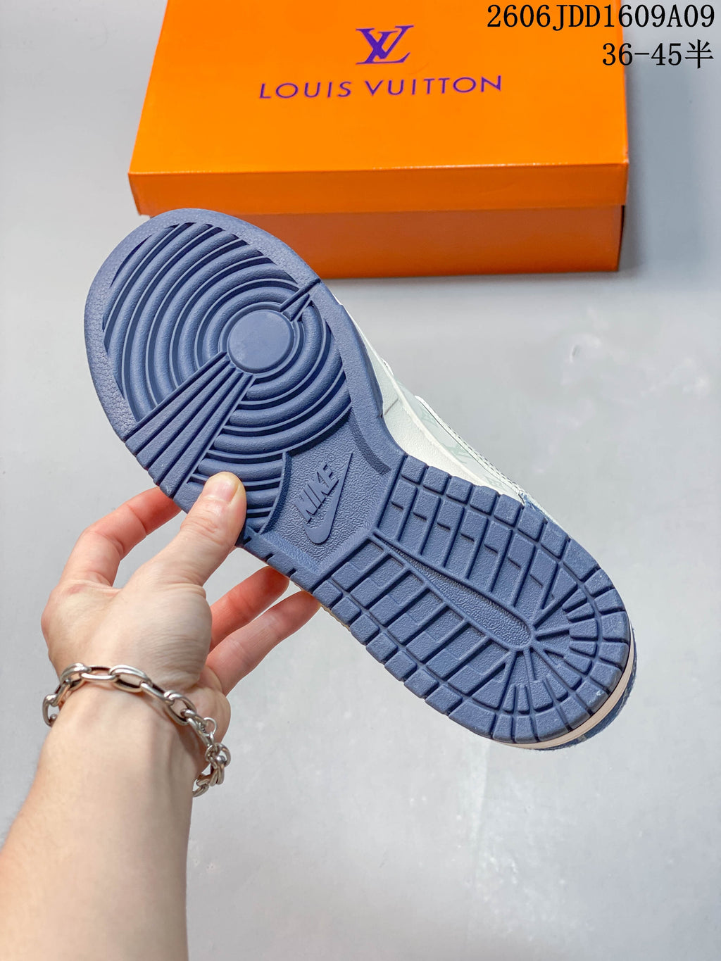 Blue patterned outsole of a cream and blue low-top sneaker