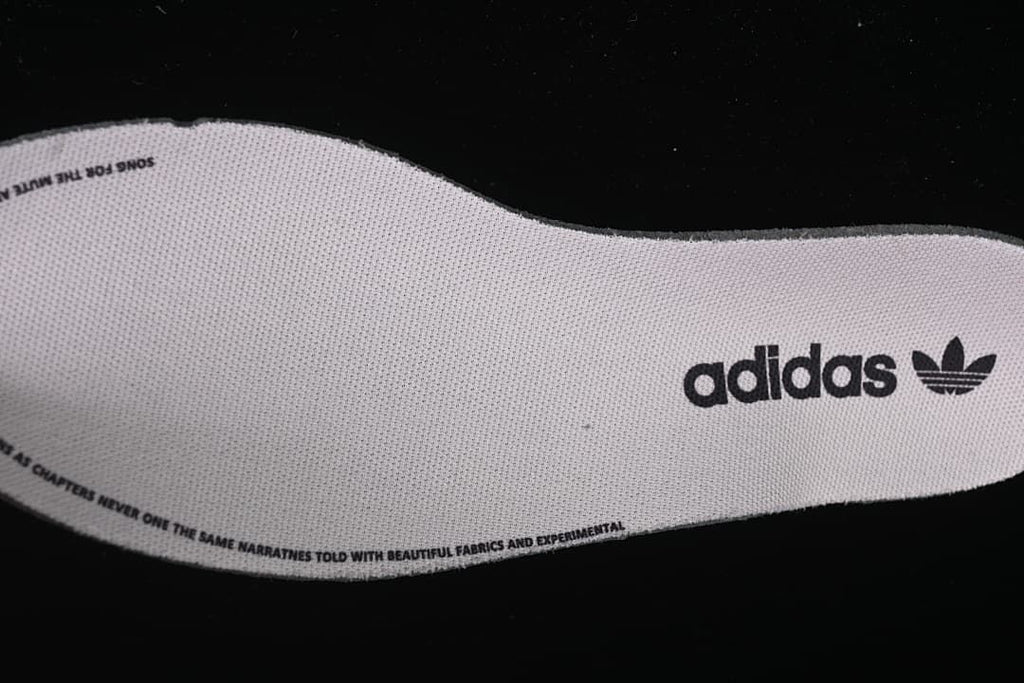 Close-up of an adidas-branded insole with printed text around its edge.