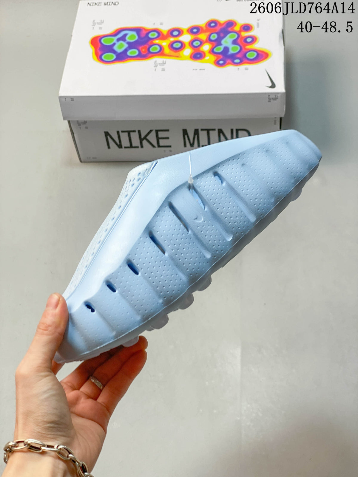 Side profile showing the perforated upper and sculpted sole of the light blue mule