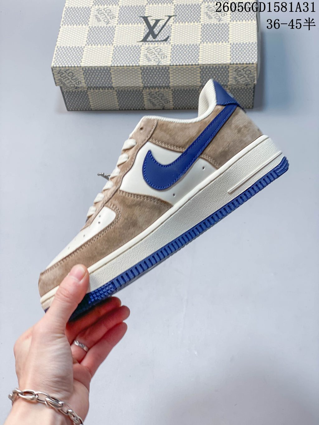 Side view of a cream and taupe low-top sneaker with a blue Swoosh and outsole