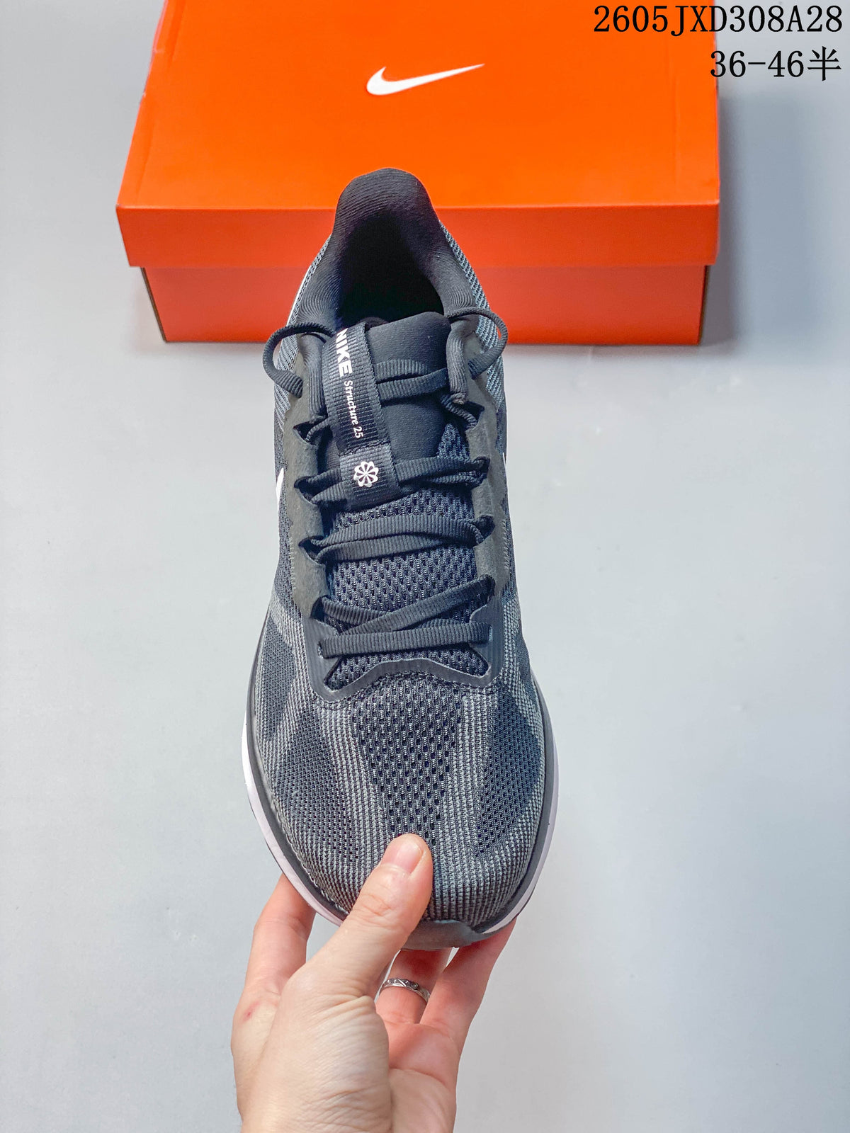 Front view of a gray running shoe with dark laces and a mesh-patterned upper.