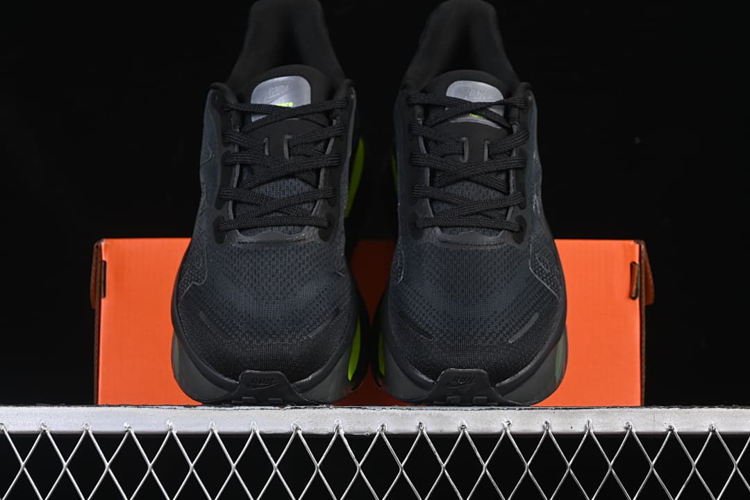 Front view of the pair of black running shoes with volt accents behind them.