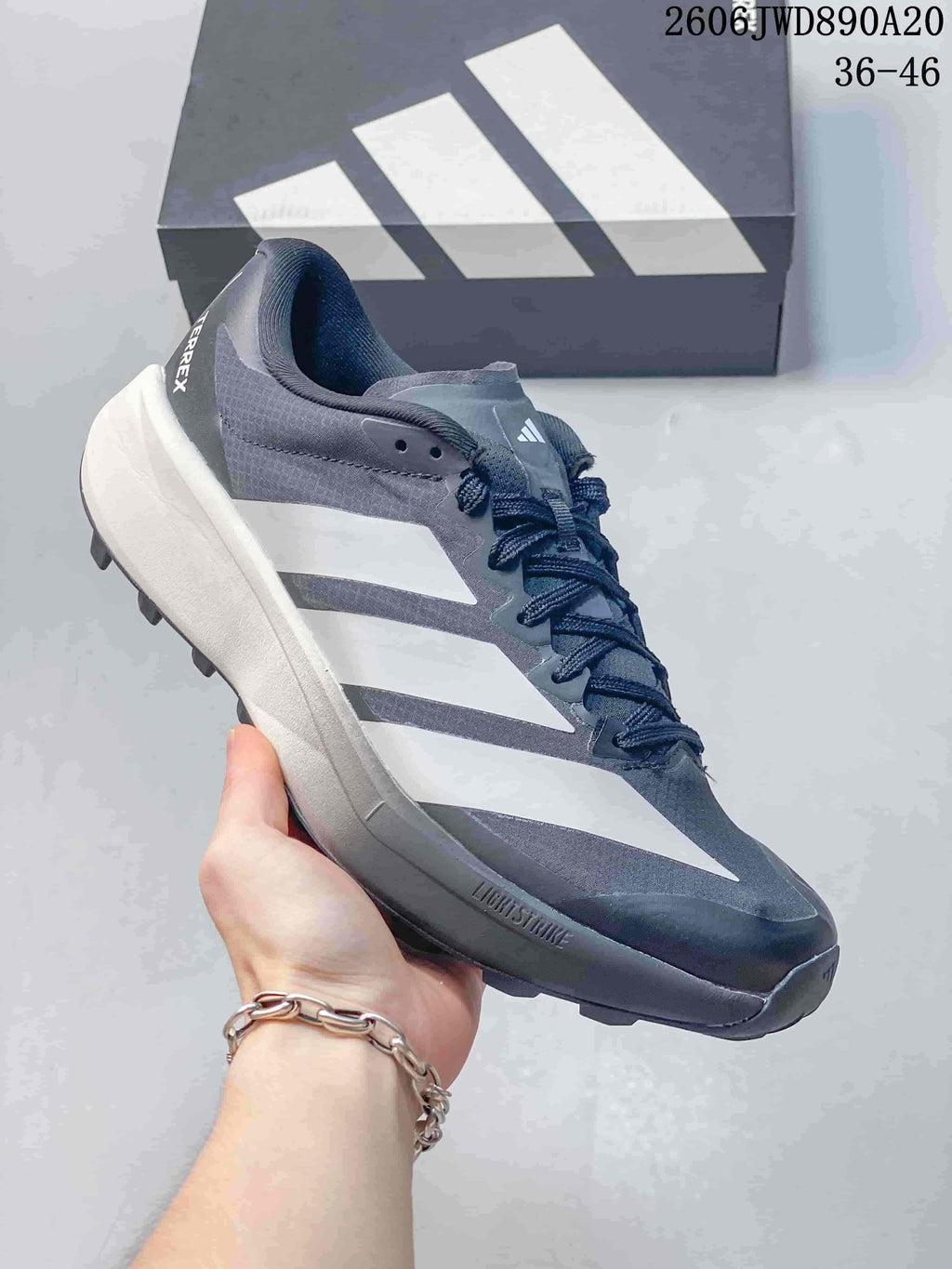 Side view of the gray adidas Terrex shoe with white stripes and lugged outsole