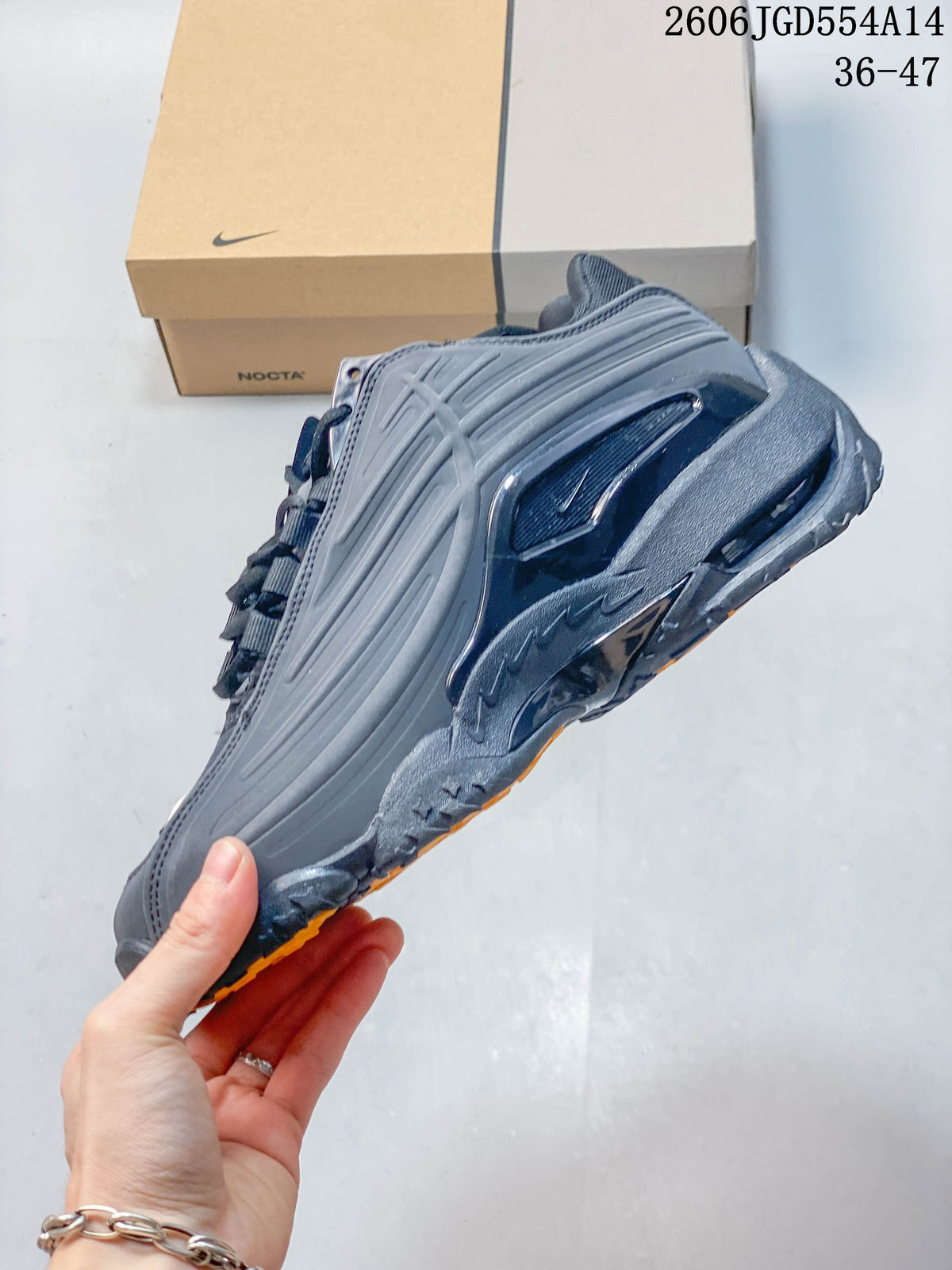 Side view of a dark gray Nike NOCTA Hot Step 2 sneaker with sculpted panels