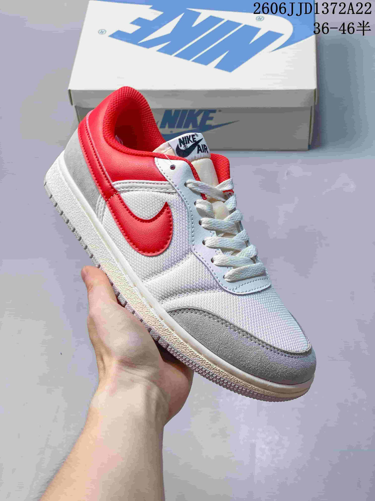Single white and gray Nike Air Jordan Skyline sneaker with red accents, held in hand.