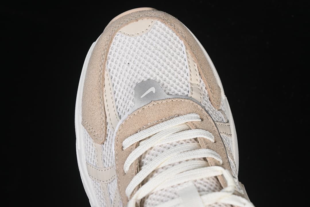 Top view of the mesh toe, beige overlays, and laces