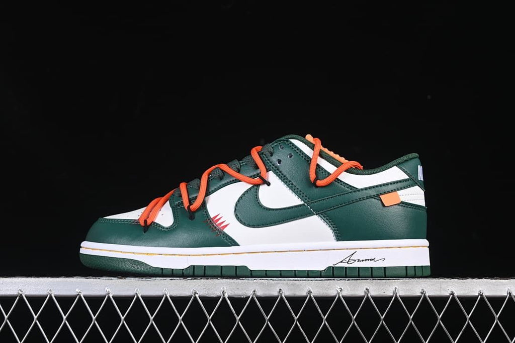 Side profile of the green and white sneaker with orange laces