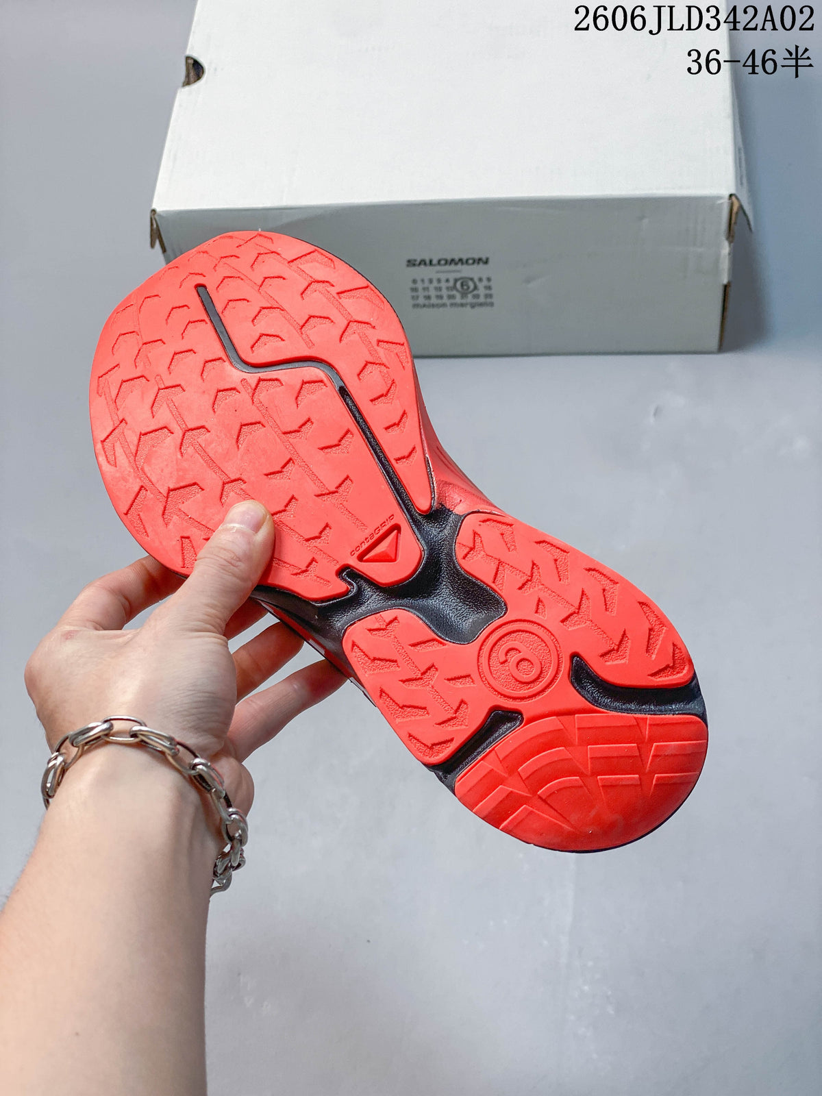 View of the orange lug-pattern outsole on a Salomon trail shoe.