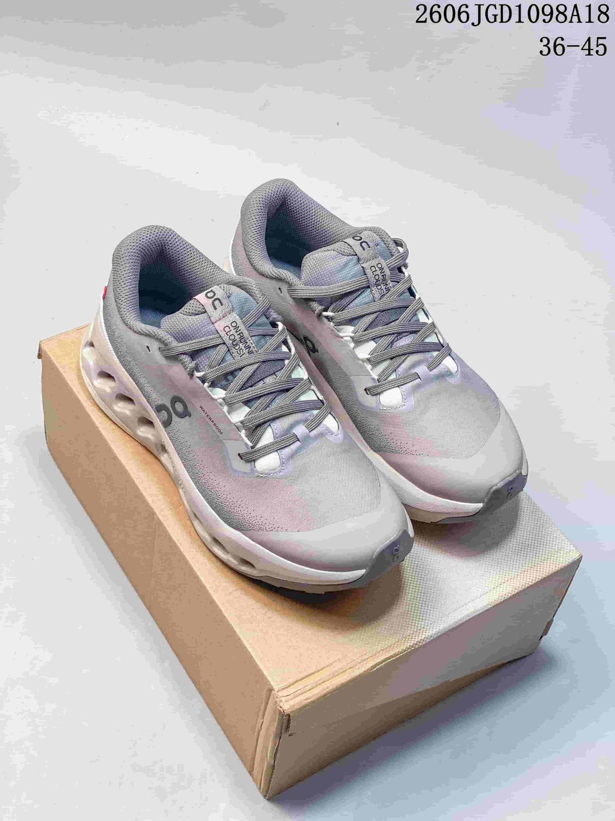 Pair of light gray On Cloudmonster 3 shoes shown from the front.