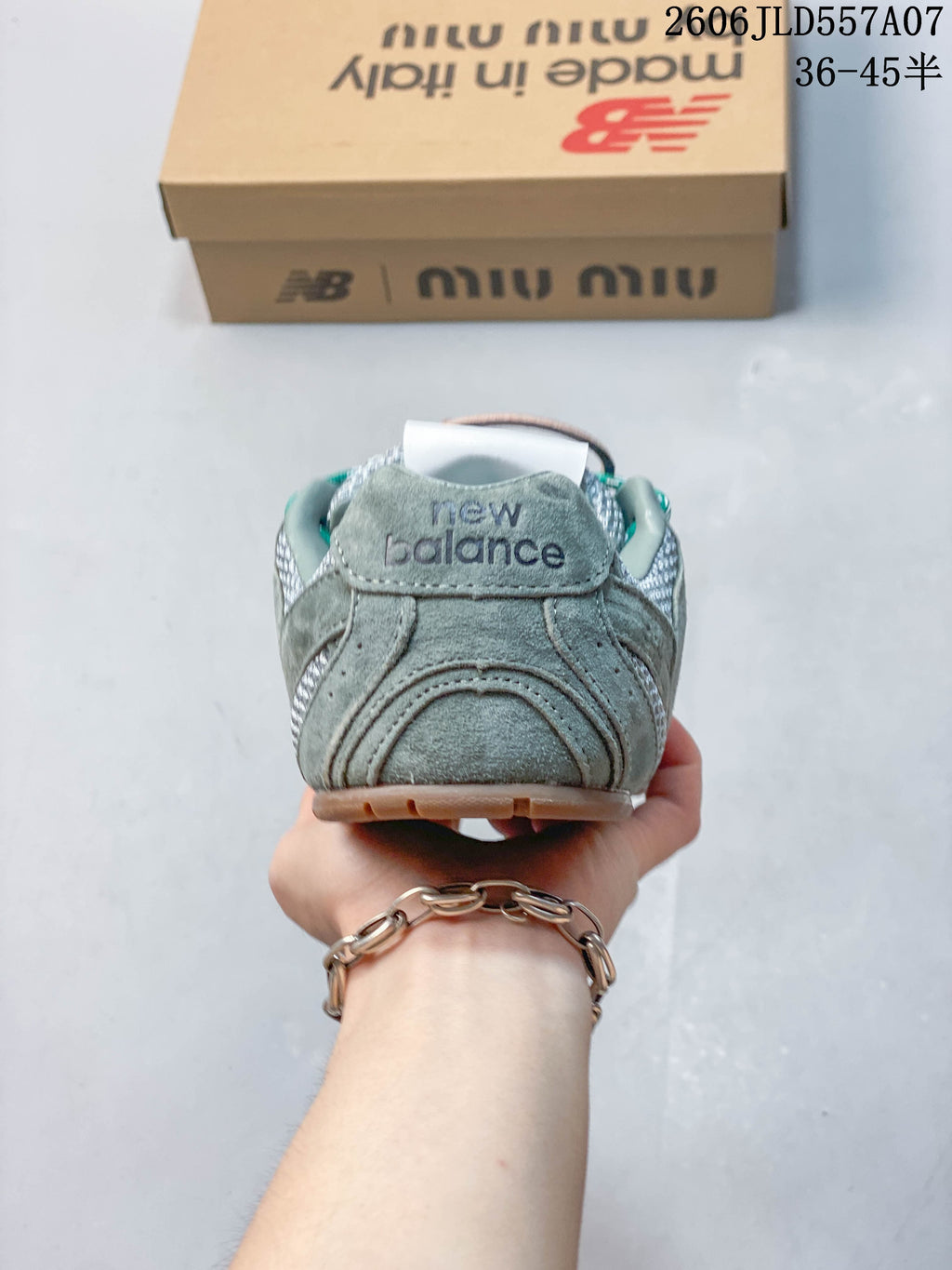 Rear view of the sage-green and silver sneaker showing the heel panel and branding