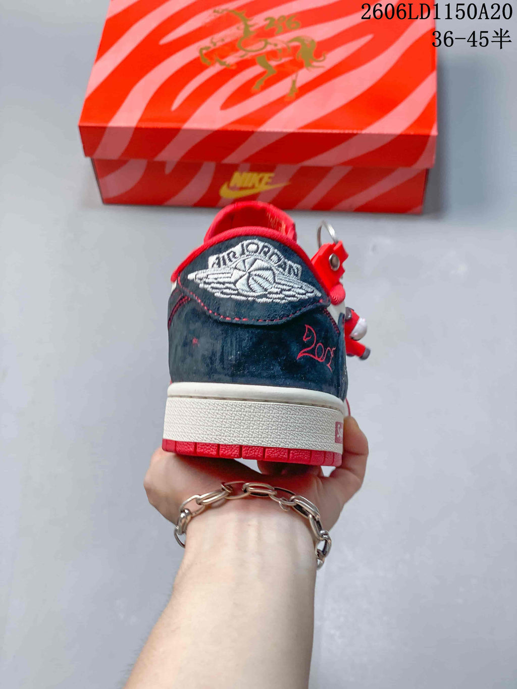 Rear view of a low-top sneaker with a dark navy heel panel and embroidered branding