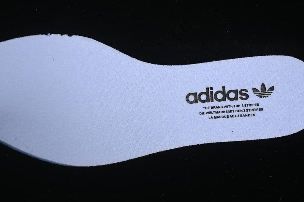 Light-colored insole with adidas Trefoil branding.