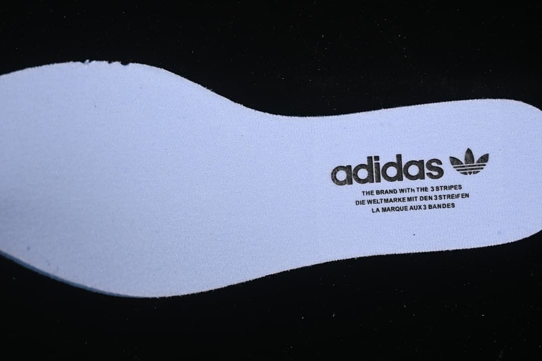 Light-colored insole with adidas Trefoil branding.