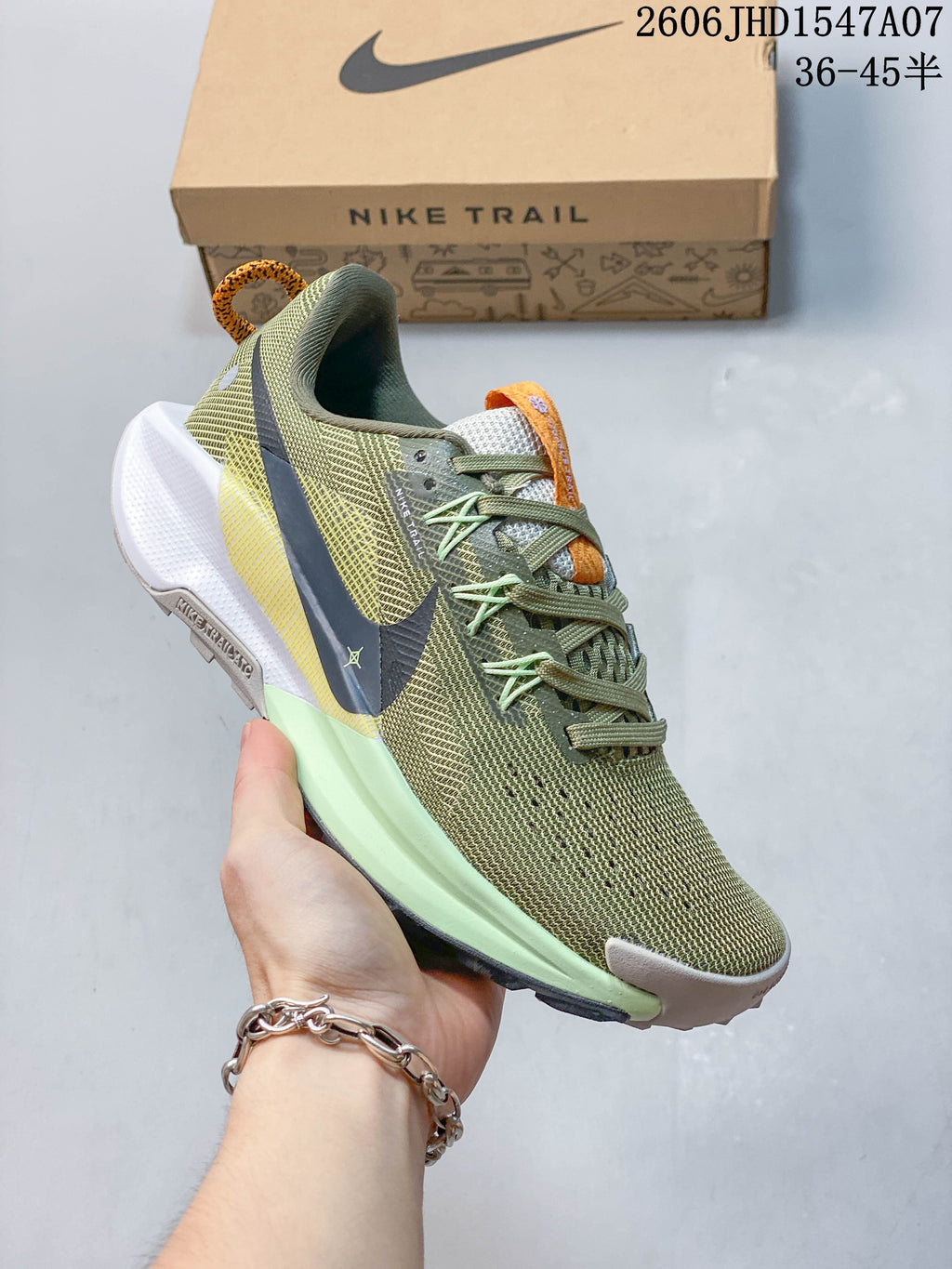 Angled side view of the olive green Nike trail shoe with a dark swoosh and pale green midsole.