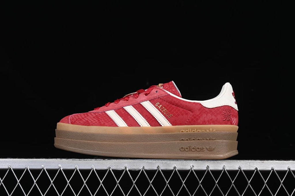 Red adidas Gazelle Bold low-top sneaker with white stripes and a layered gum-tone platform sole