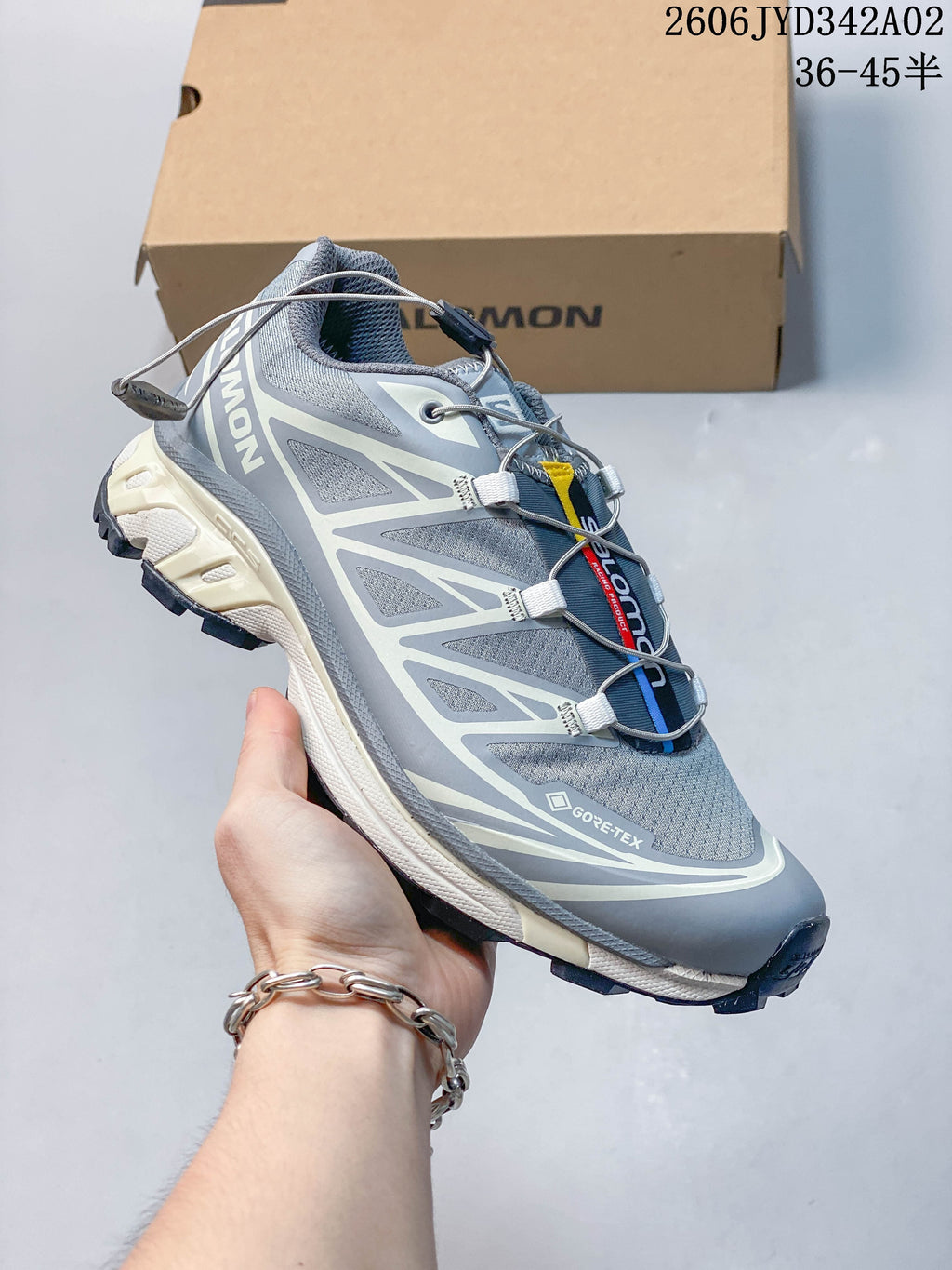 Side view of a grey Salomon trail-style shoe with cord lacing and a lugged outsole