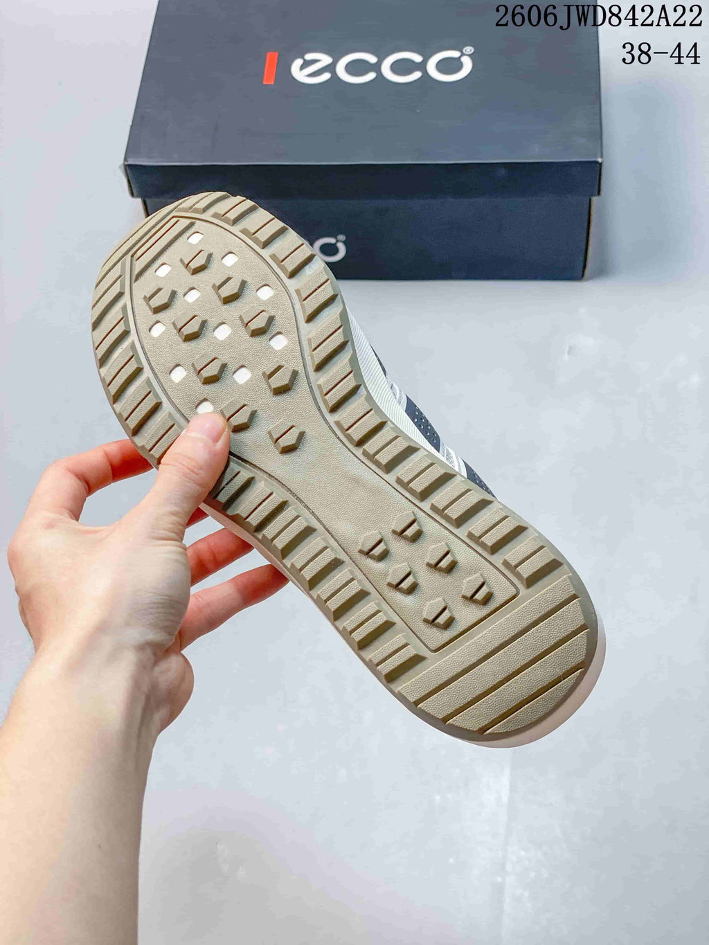Close-up of the textured beige outsole and tread pattern on the sneaker.