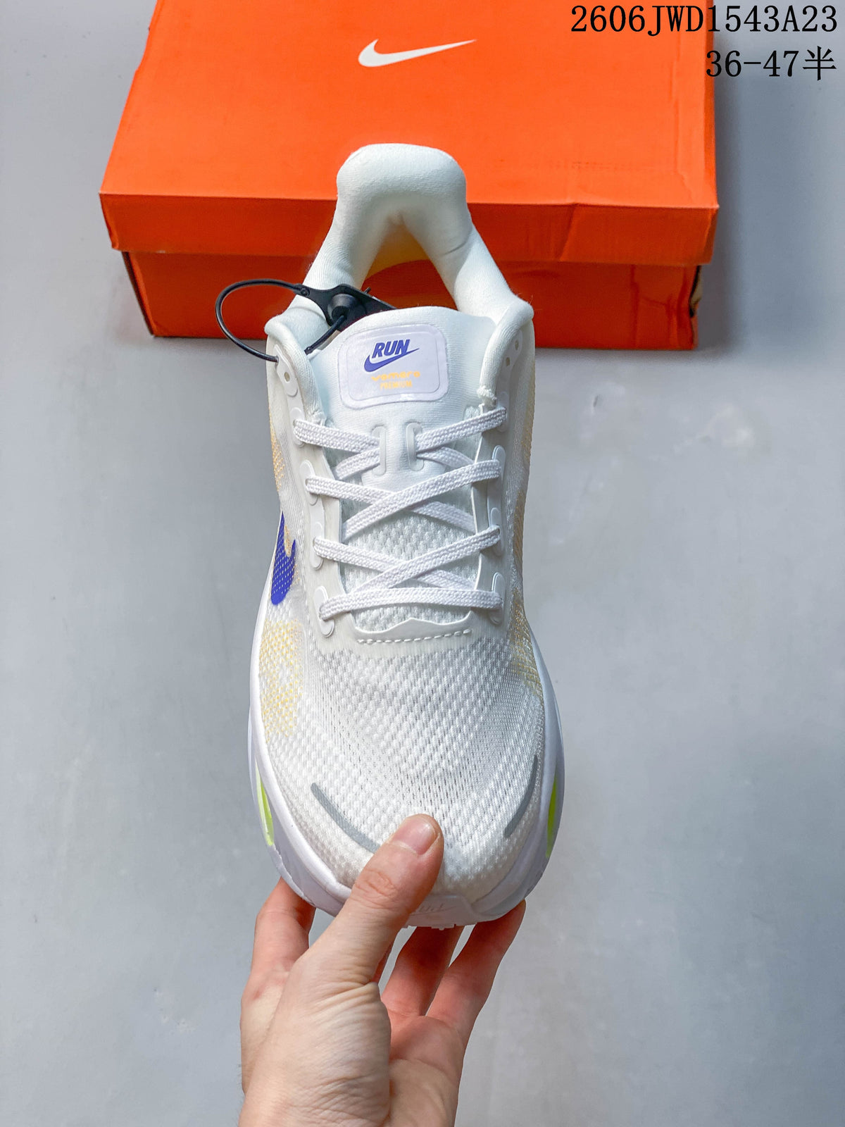 Front view of the white lace-up running shoe with blue tongue detail