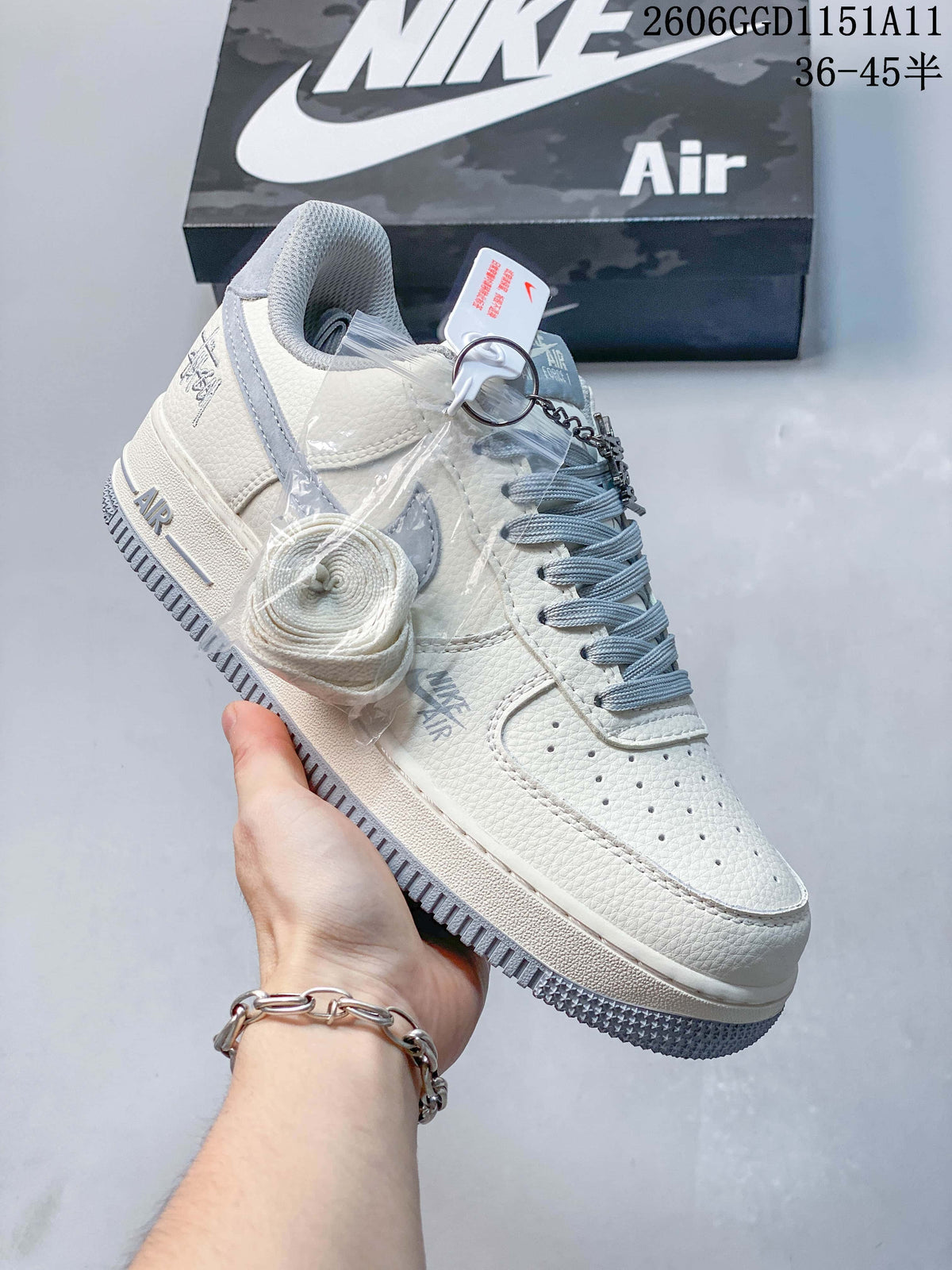 Angled view of the off-white and gray sneakers with charm and spare lace accessory