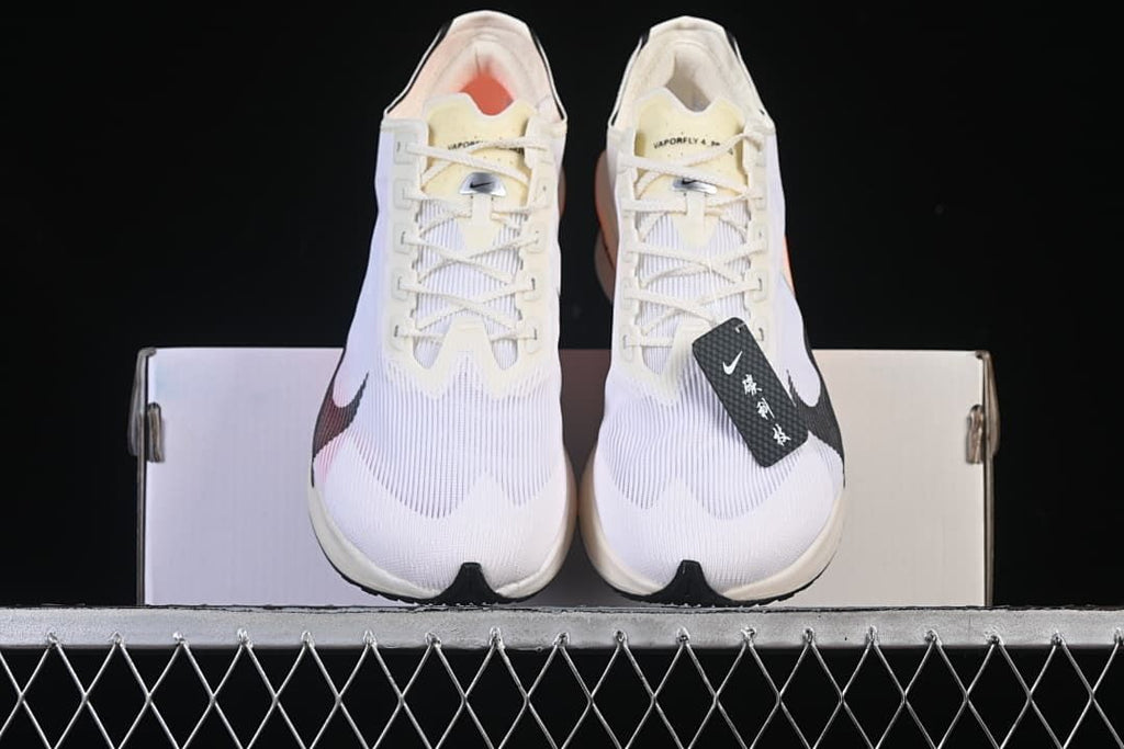 Front view of the pair showing the white uppers, black Swoosh details, and orange interiors