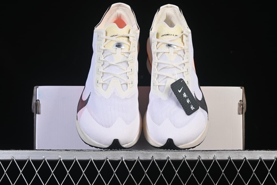 Front view of the pair showing the white uppers, black Swoosh details, and orange interiors