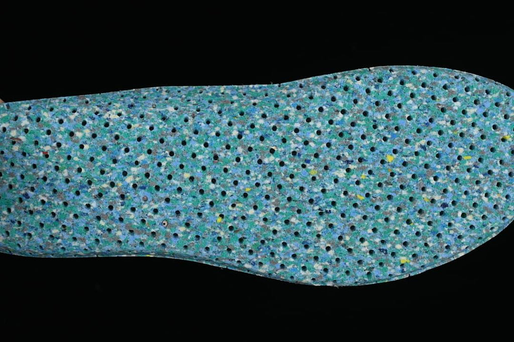Close-up of a textured blue shoe insole with perforations.