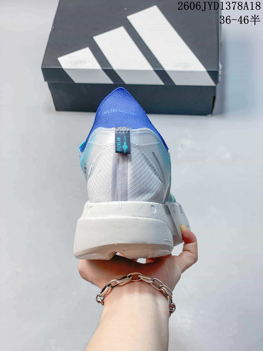 Rear view of the shoe showing a white heel, blue collar, and patterned upper