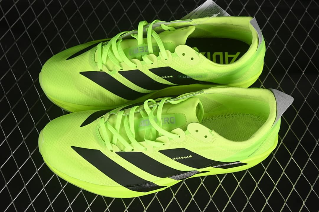 Pair of neon yellow running shoes with black stripes