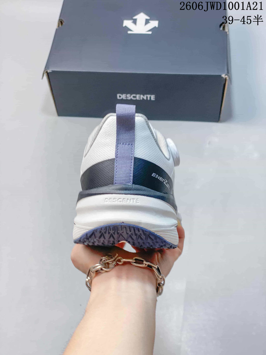 Rear view of a white DESCENTE sneaker showing the heel and outsole tread