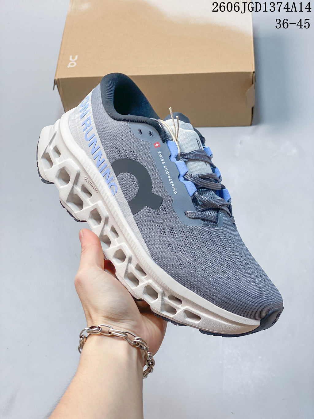 Angled side view highlighting the grey upper, branding and chunky white midsole.